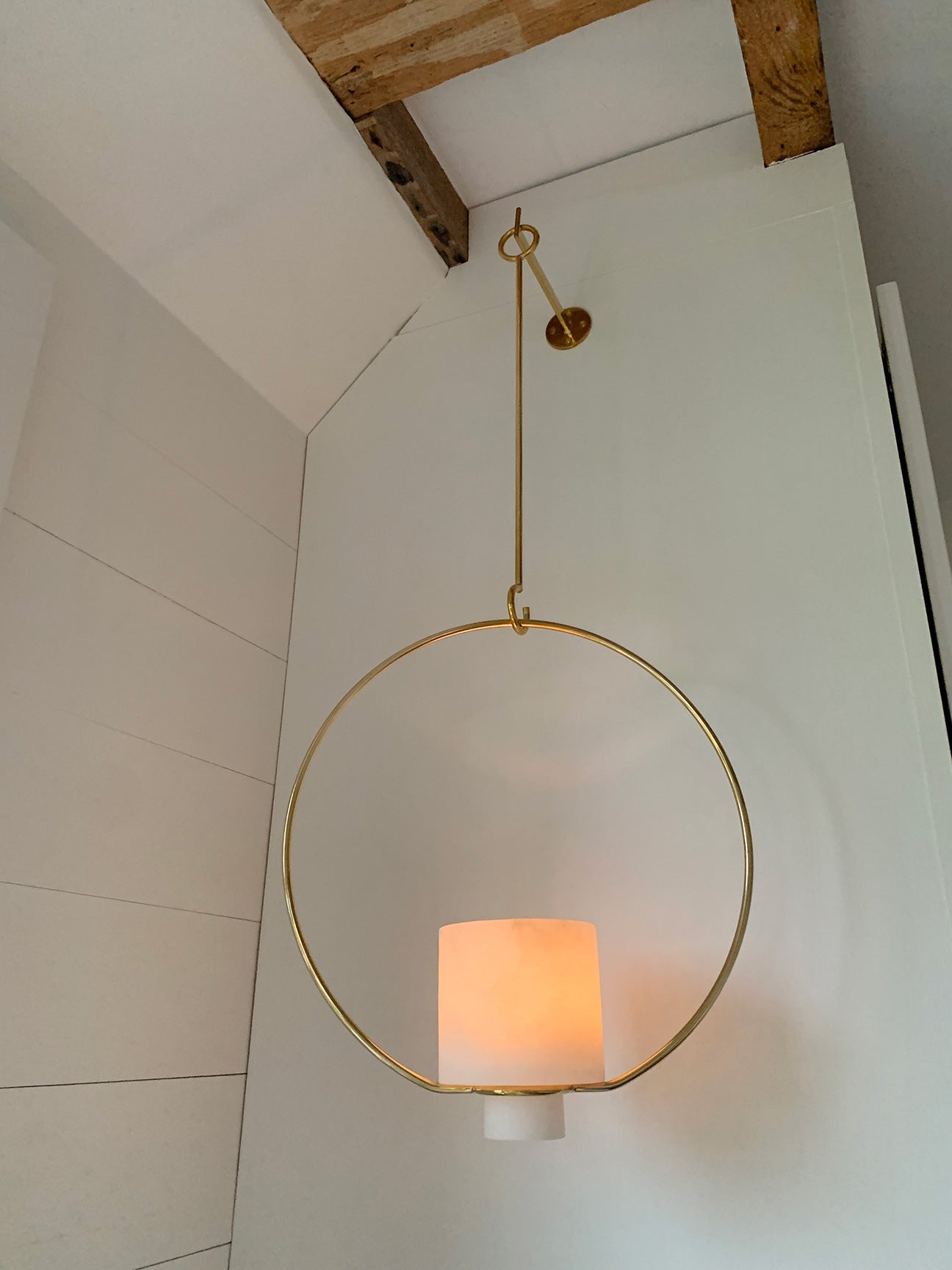 Image of M+A NYC Hanging Planter/Lantern in Alabaster and Brass lit up with a glass votive inside.