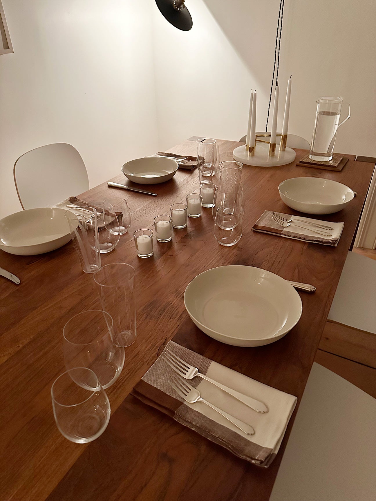 IMAGE OF M+A NYC COLORBLOCK NAPKINS IN KORA/EARTH BEING USED IN A TABLE SETTING ALONG WITH SILVER, PORCELAIN, AND GLASS PIECES