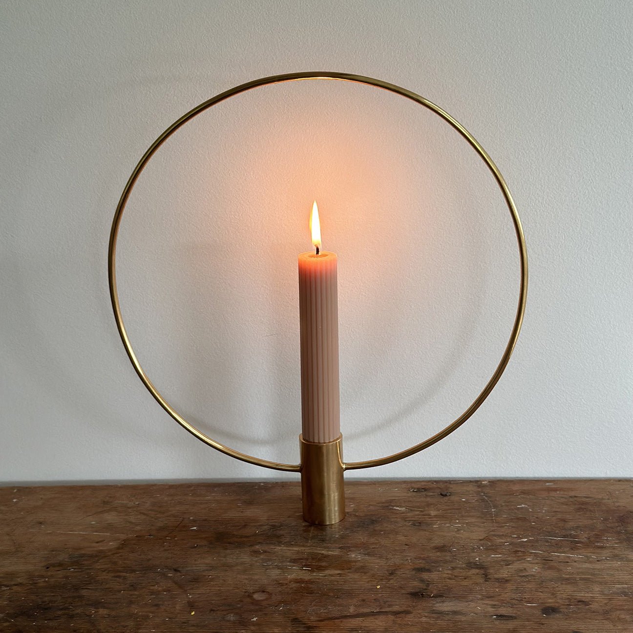 Photoof M+A NYC Halo Taper Stand with Lit Candle on a farmhouse table from the 1800s