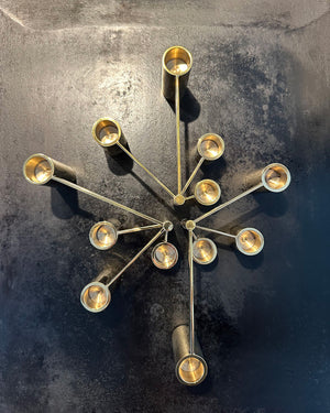 Image of 3 Solid Brass Modular Swing Arm Candelabras sitting on a black cast iron surface.
