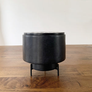 Image of M+A NYC Planter/Vase Set with Ikebana Lid in black soapstone sitting on a wooden table.