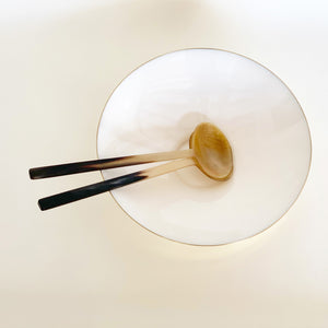 Image of a pair of M+A NYC Amber Horn Servers in a Kora Enamel Bowl