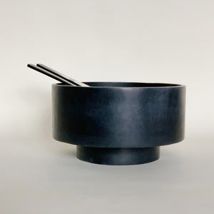 Image of a pair of M+A NYC Horn Servers in a black soapstone bowl.