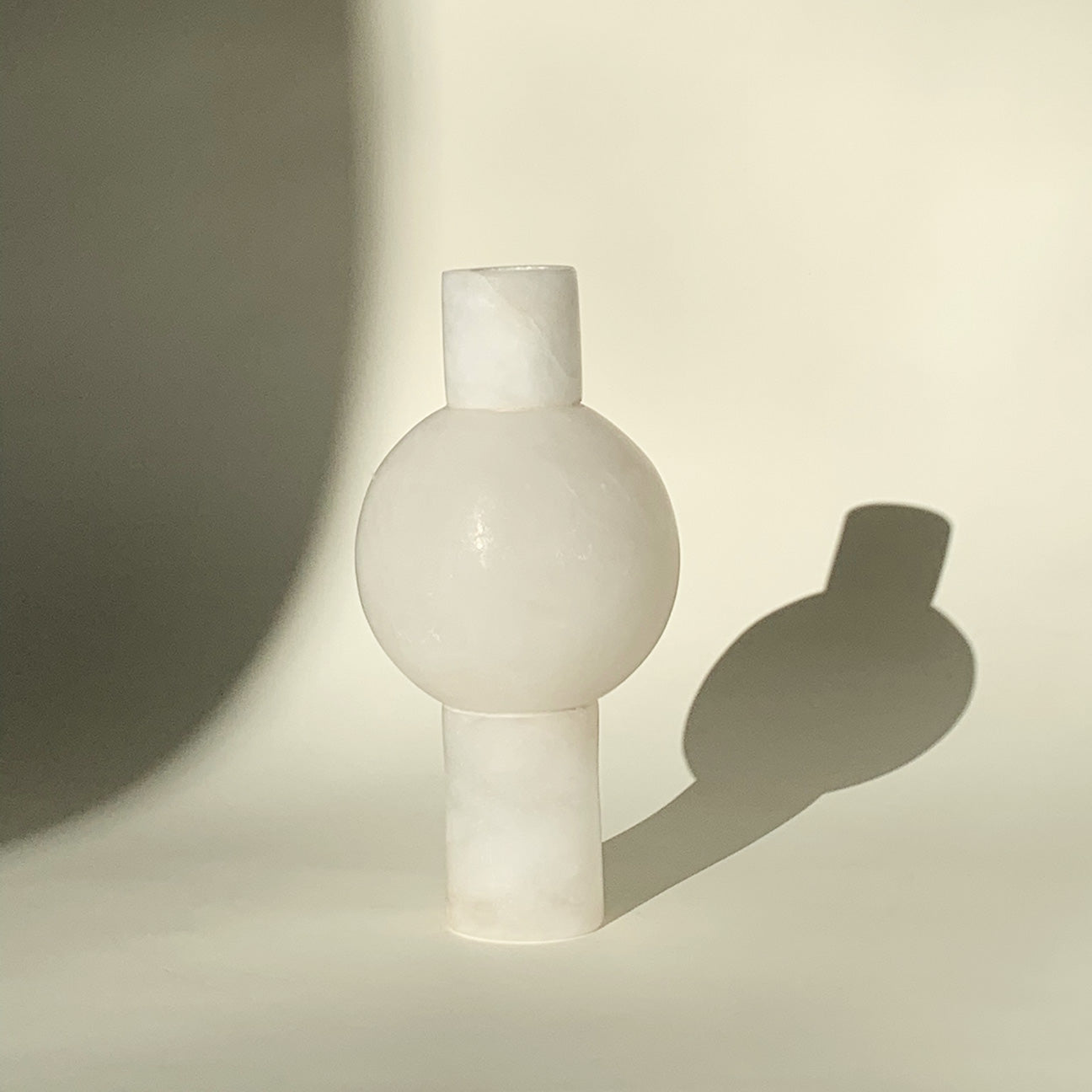 M+A Alabaster Keyhole Vase casting a big shadow in the late afternoon sun.