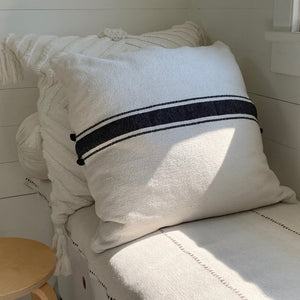 Image of M+A NYC Ribbon Stripe Hand Loomed 24" Pillow reclining on a daybed, and paired with the Stella 26" Pillow in Kora.