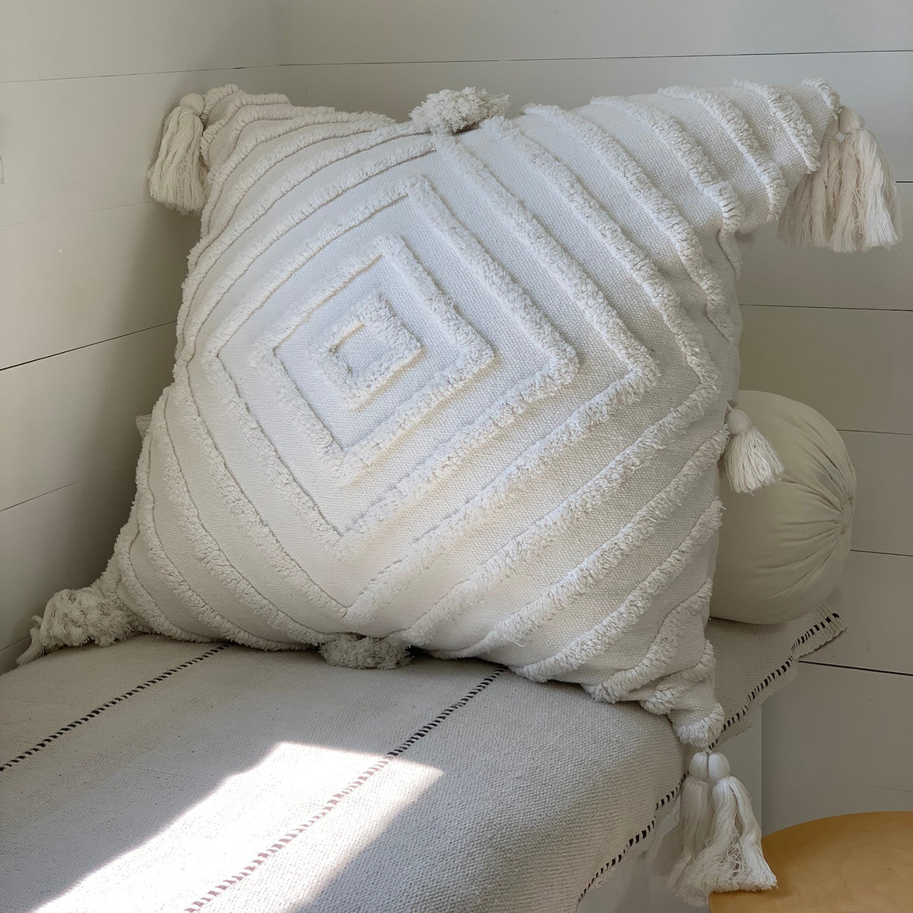 Image of M+A NYC Stella Tufted and Hand Loomed Cotton Pillow in the color Kora, shown on a daybed.