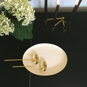 Image of M+A NYC tablescape showing our Enamel and Brass Plated Oval Tray with our Solid Brass Servers and Solid Brass Modular Swing Candelabra all resting on top of our Versatile Textile in black and kora.